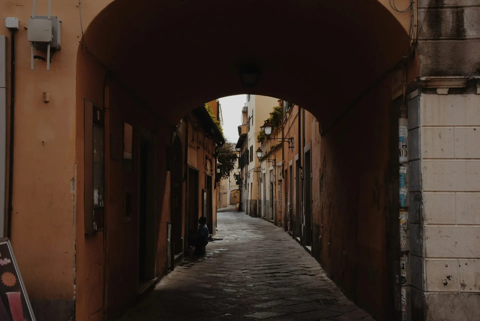 a narrow alley way with a sign on the side of it