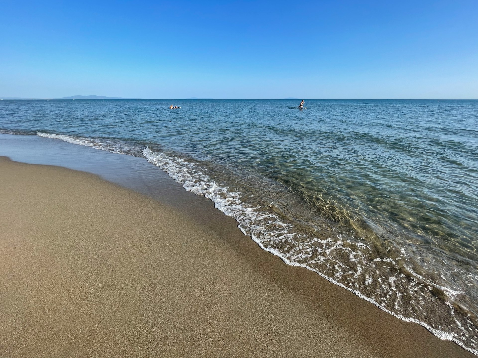 a sandy beach with waves coming in to shore